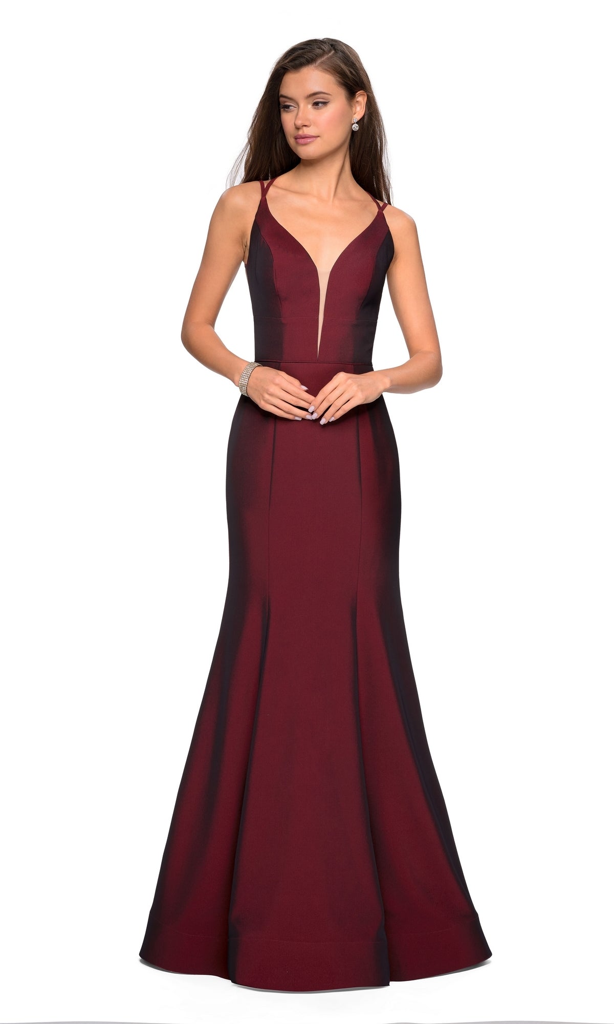 A woman models the La Femme Open-Back V-Neck Jersey Prom Dress 27446 in deep burgundy, featuring a sleeveless mermaid silhouette, plunging neckline, and double spaghetti straps against a white background.